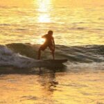 a man riding a wave on a surf board on a body of water