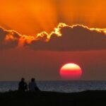 a person standing in front of a sunset