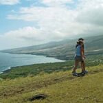 a man standing on a grassy hill