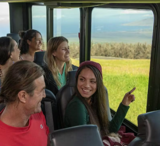 a group of people sitting in front of a window on a Hawaii tour bus in Maui
